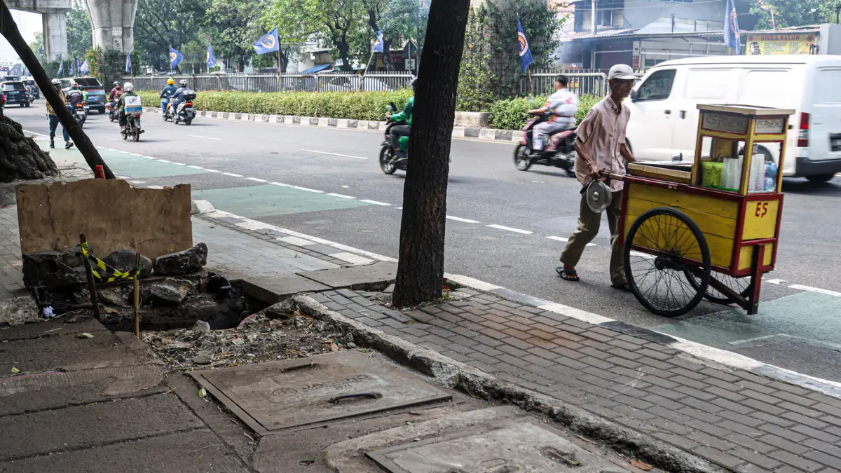 Sejumlah pengguna jalan melintas di bekas JPO yang rusak akibat diatabrak truk di Jalan Tendean, Senin (20/06/2026). (Hanung Hambara/Jawa Pos)