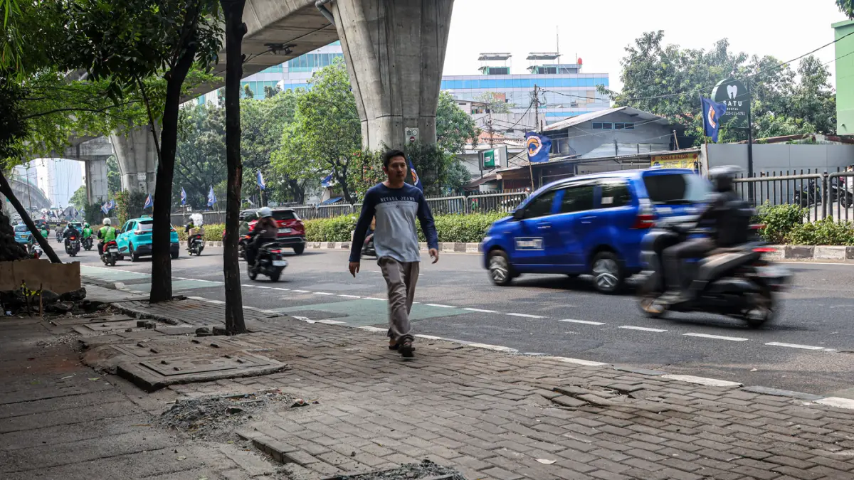 Sejumlah pengguna jalan melintas di bekas JPO yang rusak akibat diatabrak truk di Jalan Tendean, Senin (20/06/2026). (Hanung Hambara/Jawa Pos)