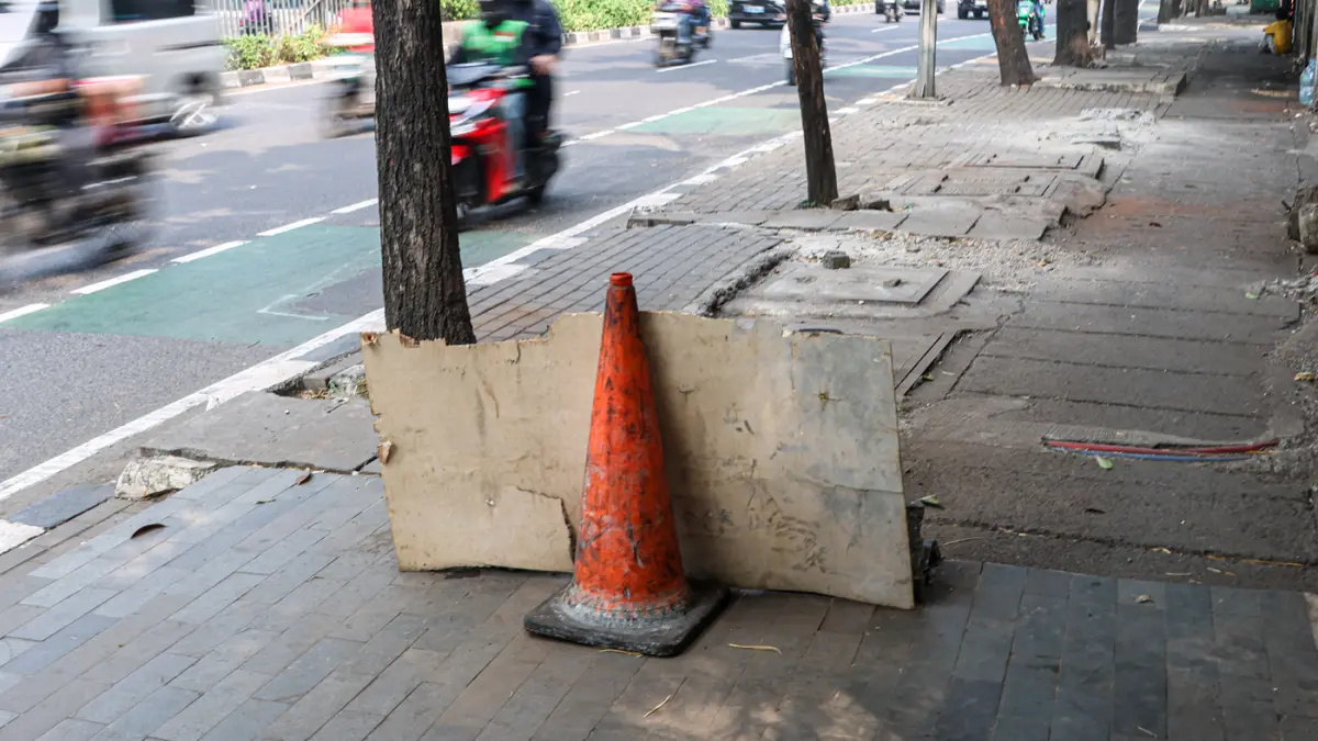 Sejumlah pengguna jalan melintas di bekas JPO yang rusak akibat diatabrak truk di Jalan Tendean, Senin (20/06/2026). (Hanung Hambara/Jawa Pos)