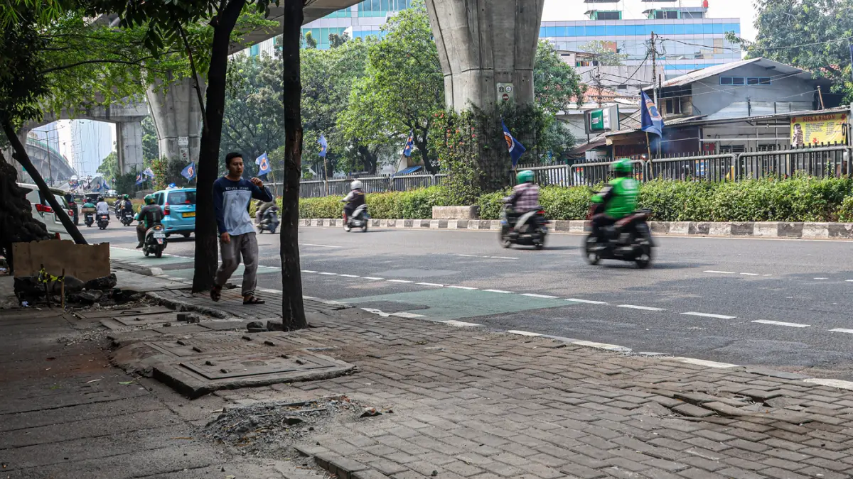 Sejumlah pengguna jalan melintas di bekas JPO yang rusak akibat diatabrak truk di Jalan Tendean, Senin (20/06/2026). (Hanung Hambara/Jawa Pos)