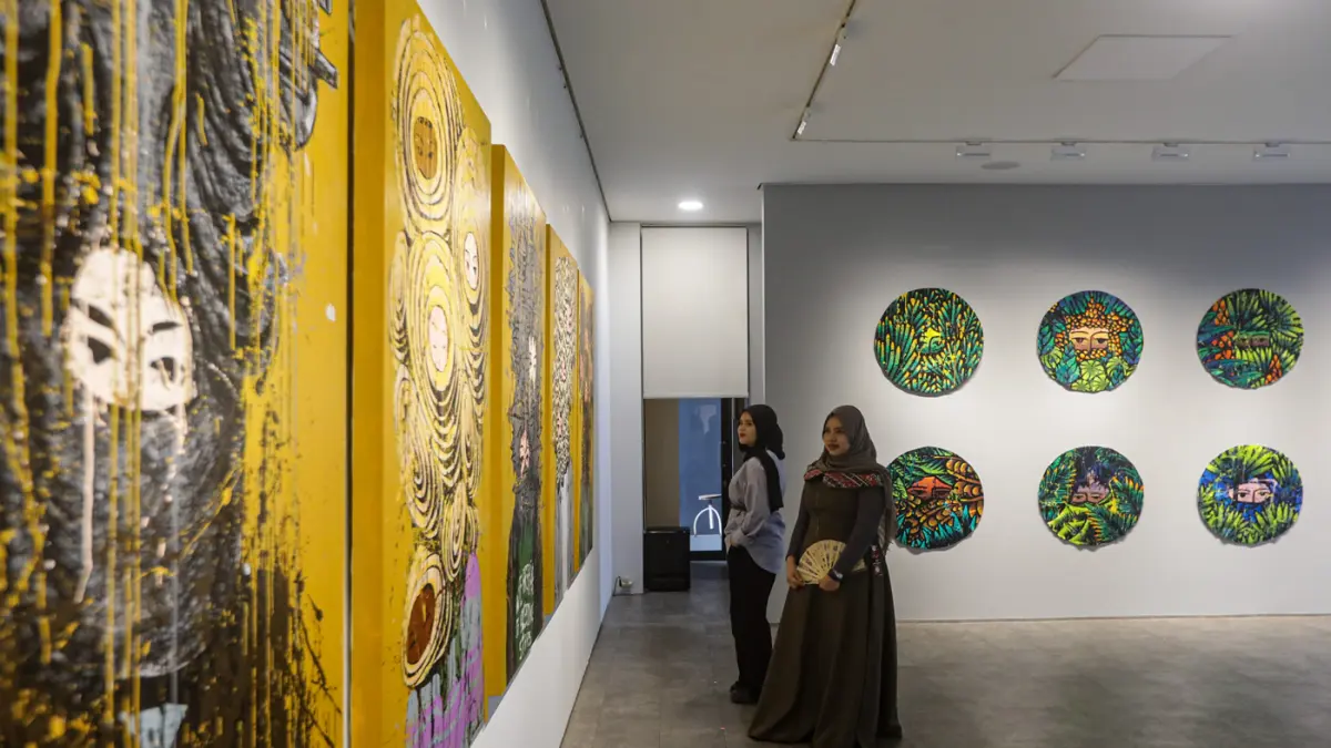Pengunjung salah satu karya pada pameran Tropical Aliens di Nadi Gallery, Kembangan, Jakarta, Jumat (24/7/2026). (Hanung Hambara/Jawa Pos)