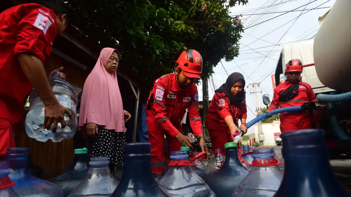 Petugas Palang Merah Indonesia (PMI) menyalurkan bantuan air bersih kepada warga terdampak kekeringan di RW 08, Cipayung Jaya, Kota Depok, Jawa Barat, Jumat (24/7/2026). (Dery Ridwansah/ JawaPos.com)