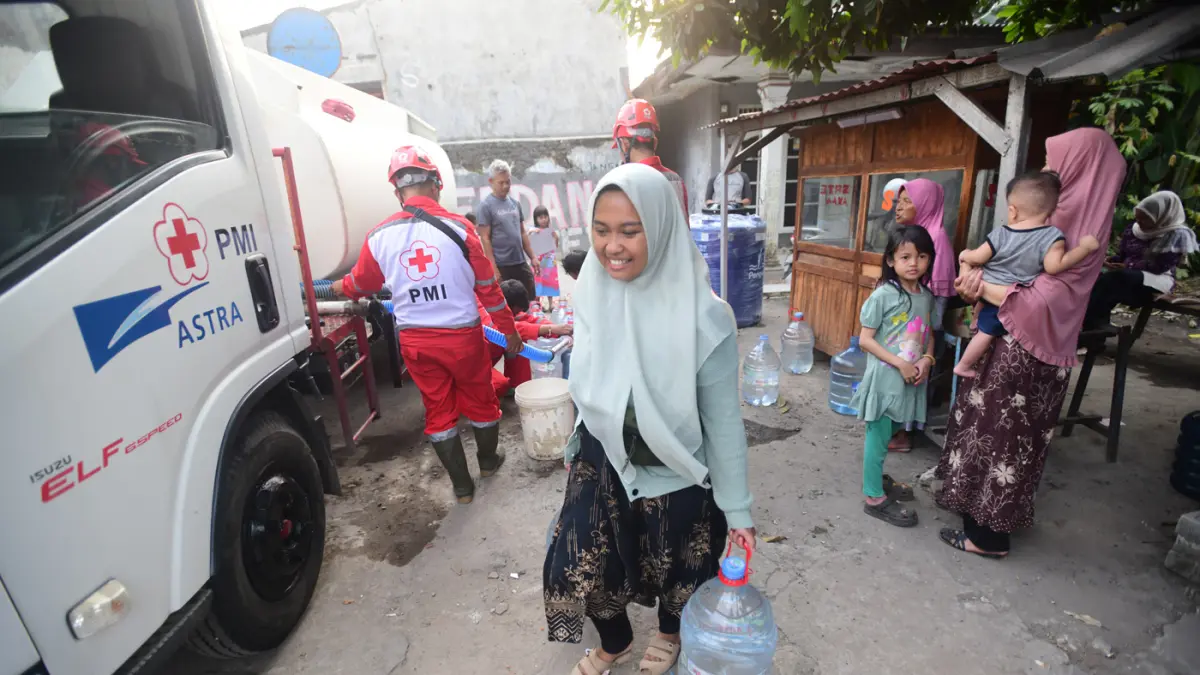 Petugas Palang Merah Indonesia (PMI) menyalurkan bantuan air bersih kepada warga terdampak kekeringan di RW 08, Cipayung Jaya, Kota Depok, Jawa Barat, Jumat (24/7/2026). (Dery Ridwansah/ JawaPos.com)