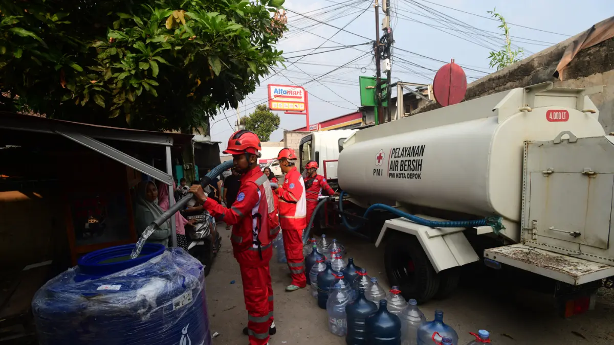 Petugas Palang Merah Indonesia (PMI) menyalurkan bantuan air bersih kepada warga terdampak kekeringan di RW 08, Cipayung Jaya, Kota Depok, Jawa Barat, Jumat (24/7/2026). (Dery Ridwansah/ JawaPos.com)