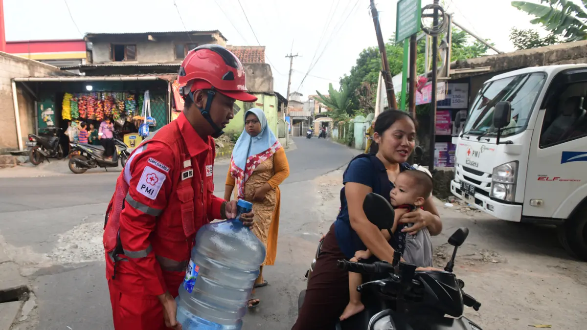 Petugas Palang Merah Indonesia (PMI) menyalurkan bantuan air bersih kepada warga terdampak kekeringan di RW 08, Cipayung Jaya, Kota Depok, Jawa Barat, Jumat (24/7/2026). (Dery Ridwansah/ JawaPos.com)