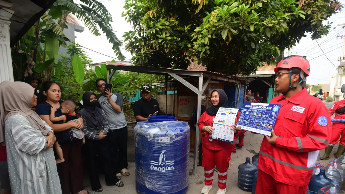 Petugas Palang Merah Indonesia (PMI) menyalurkan bantuan air bersih kepada warga terdampak kekeringan di RW 08, Cipayung Jaya, Kota Depok, Jawa Barat, Jumat (24/7/2026). (Dery Ridwansah/ JawaPos.com)