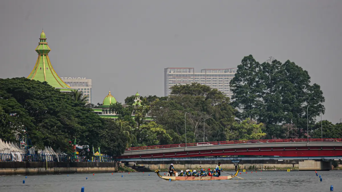 Sejumlah peserta berkompetisi dalam lomba dayung perahu naga di Sungai Cisadane, Kota Tangerang. (Hanung Hambara/Jawa Pos)