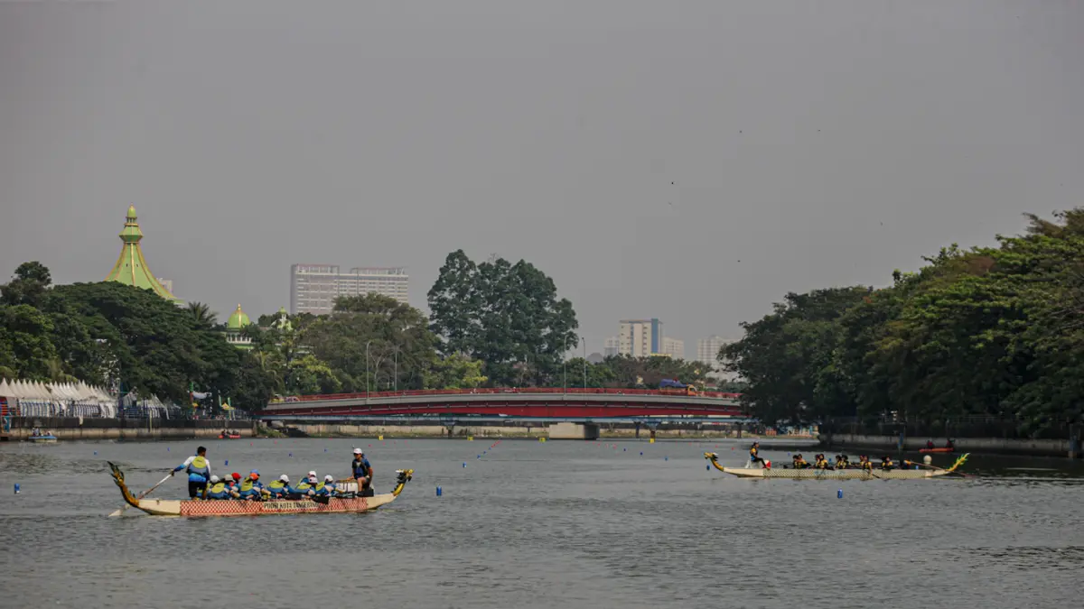 Sejumlah peserta berkompetisi dalam lomba dayung perahu naga di Sungai Cisadane, Kota Tangerang. (Hanung Hambara/Jawa Pos)