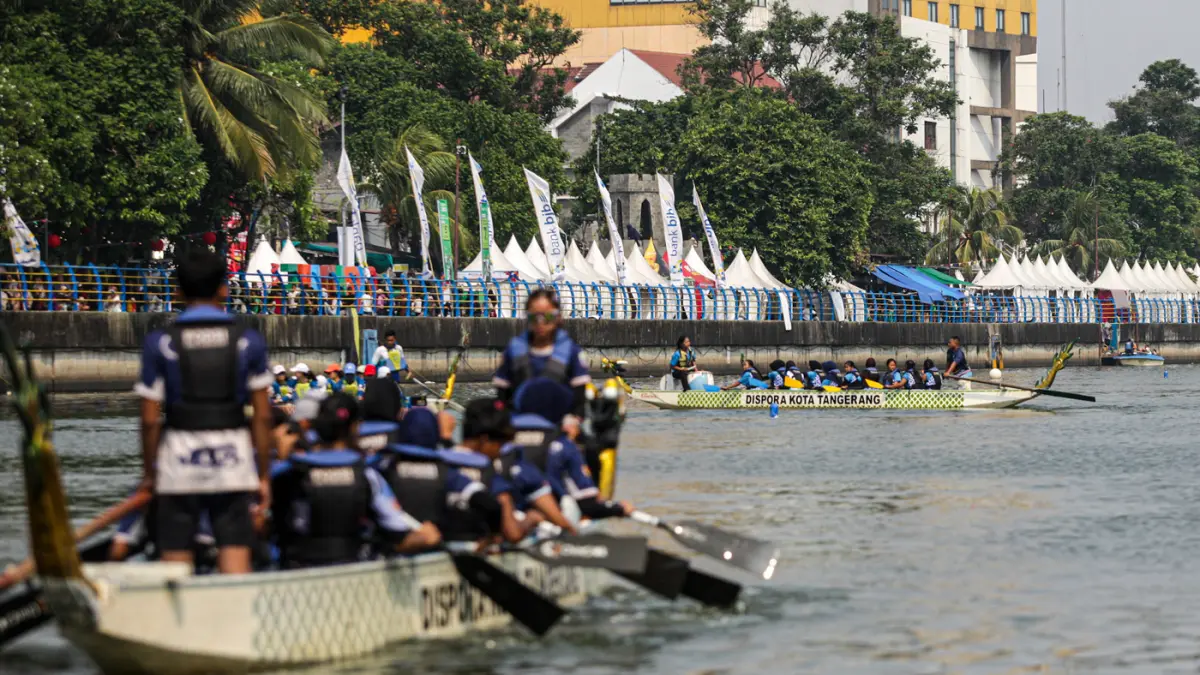 Sejumlah peserta berkompetisi dalam lomba dayung perahu naga di Sungai Cisadane, Kota Tangerang. (Hanung Hambara/Jawa Pos)