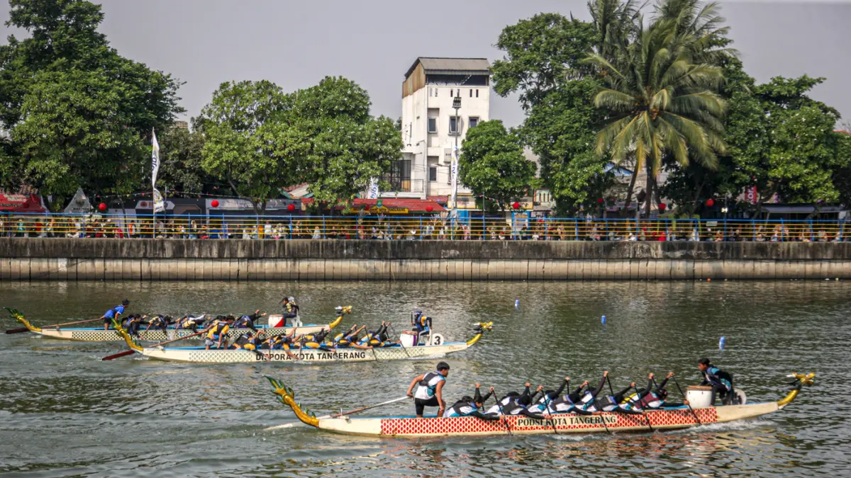 Sejumlah peserta berkompetisi dalam lomba dayung perahu naga di Sungai Cisadane, Kota Tangerang. (Hanung Hambara/Jawa Pos)