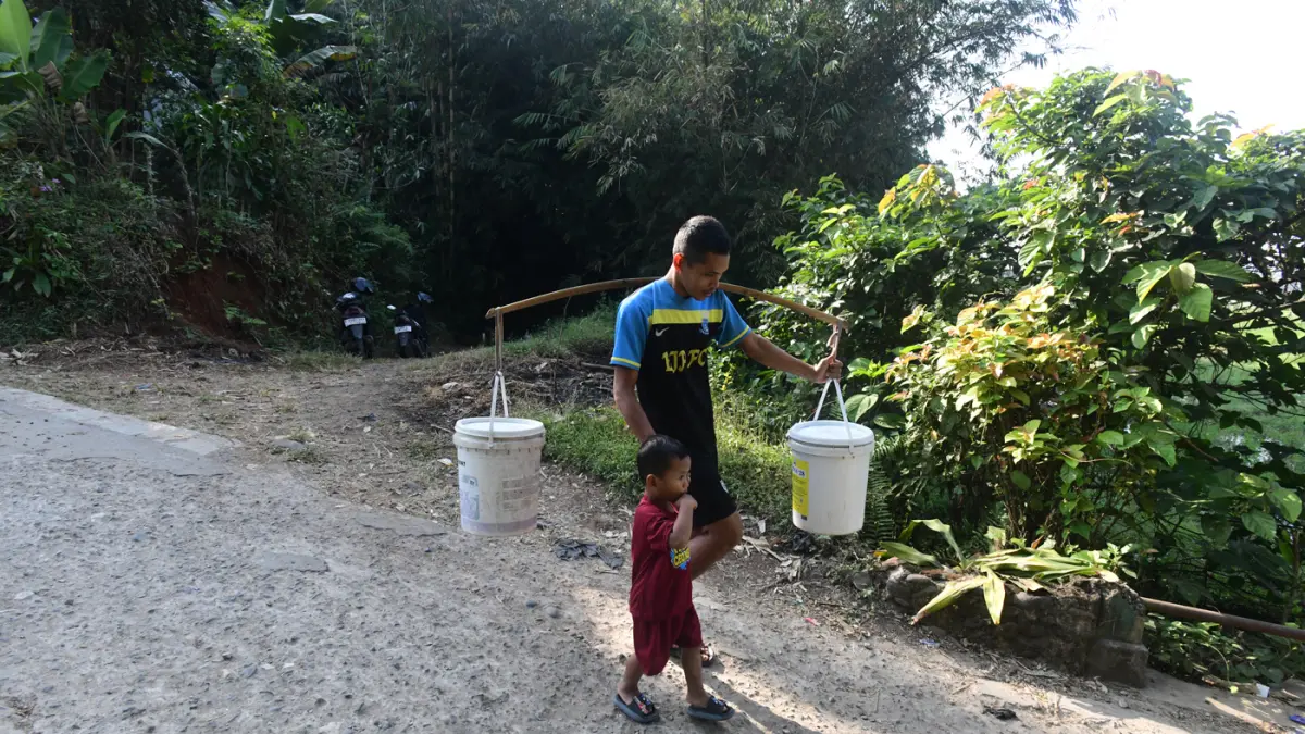 Warga mengantre untuk mengambil air dari satu-satunya sumber mata air yang masih mengalir di Desa Cidokom, Kabupaten Bogor, Jawa Barat, Minggu (26/7/2026). (Dery Ridwansah/ JawaPos.com)