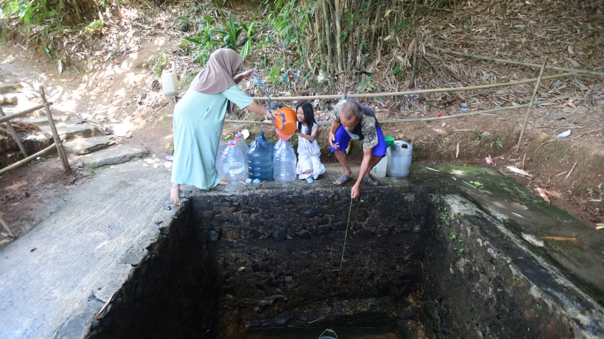 Warga mengantre untuk mengambil air dari satu-satunya sumber mata air yang masih mengalir di Desa Cidokom, Kabupaten Bogor, Jawa Barat, Minggu (26/7/2026). (Dery Ridwansah/ JawaPos.com)
