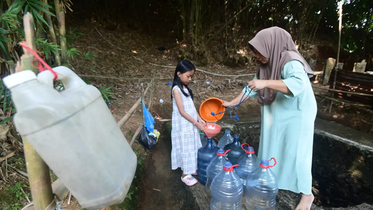 Warga mengantre untuk mengambil air dari satu-satunya sumber mata air yang masih mengalir di Desa Cidokom, Kabupaten Bogor, Jawa Barat, Minggu (26/7/2026). (Dery Ridwansah/ JawaPos.com)