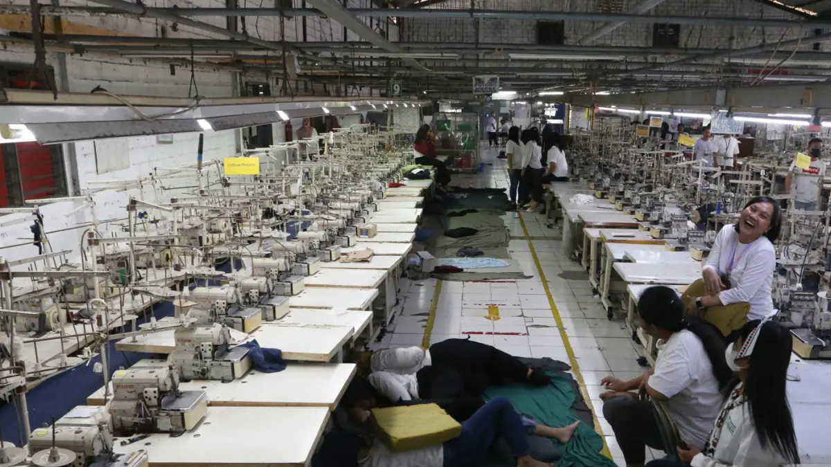 Sejumlah pekerja berada di area ruang produksi yang sudah berhenti operasionalnya selama satu bulan di pabrik PT Victory Apparel Indonesia di kawasan Pelabuhan Tanjung Emas, Semarang, Jawa Tengah, Senin (27/7/2026). (Nur Chamim/Jawa Pos Radar Semarang)