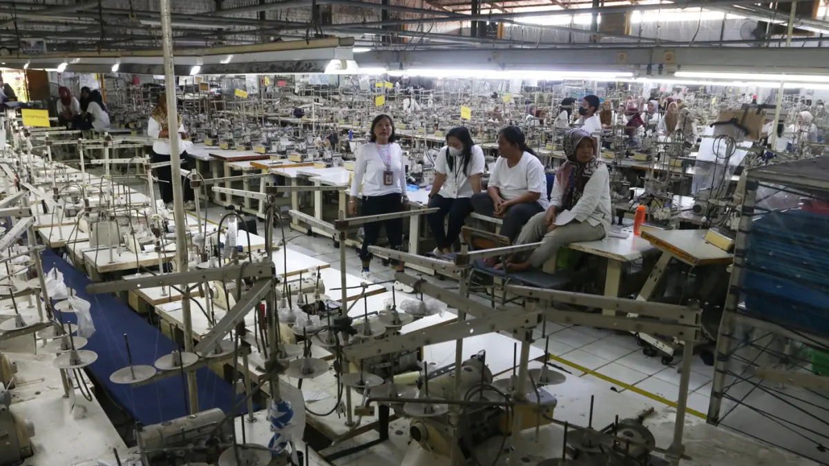 Sejumlah pekerja berada di area ruang produksi yang sudah berhenti operasionalnya selama satu bulan di pabrik PT Victory Apparel Indonesia di kawasan Pelabuhan Tanjung Emas, Semarang, Jawa Tengah, Senin (27/7/2026). (Nur Chamim/Jawa Pos Radar Semarang)