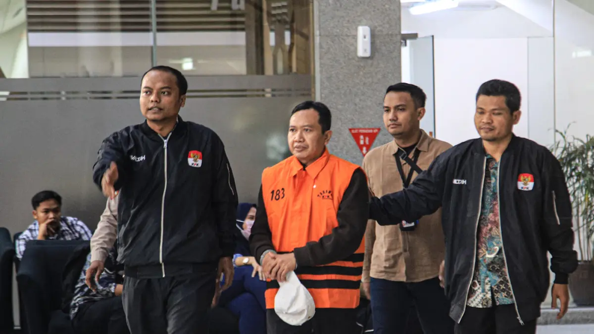 Tersangka kasus suap dana hibah Kelompok Masyarakat (Pokmas) TA 2019–2022, Moch. Mahrus (tengah) mengenakan rompi orange keluar menuju mobil tahanan usai menjalani pemeriksaan lanjutan di Gedung Merah Putih KPK, Jakarta, Selasa (28/07/2026). (Hanung Hamba