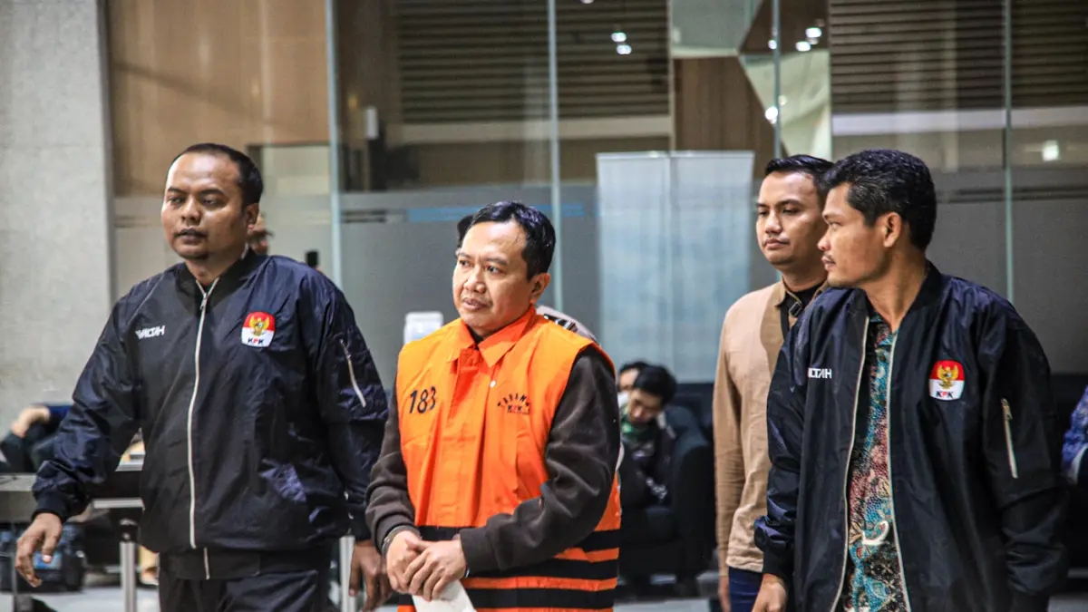 Tersangka kasus suap dana hibah Kelompok Masyarakat (Pokmas) TA 2019–2022, Moch. Mahrus (tengah) mengenakan rompi orange keluar menuju mobil tahanan usai menjalani pemeriksaan lanjutan di Gedung Merah Putih KPK, Jakarta, Selasa (28/07/2026). (Hanung Hamba