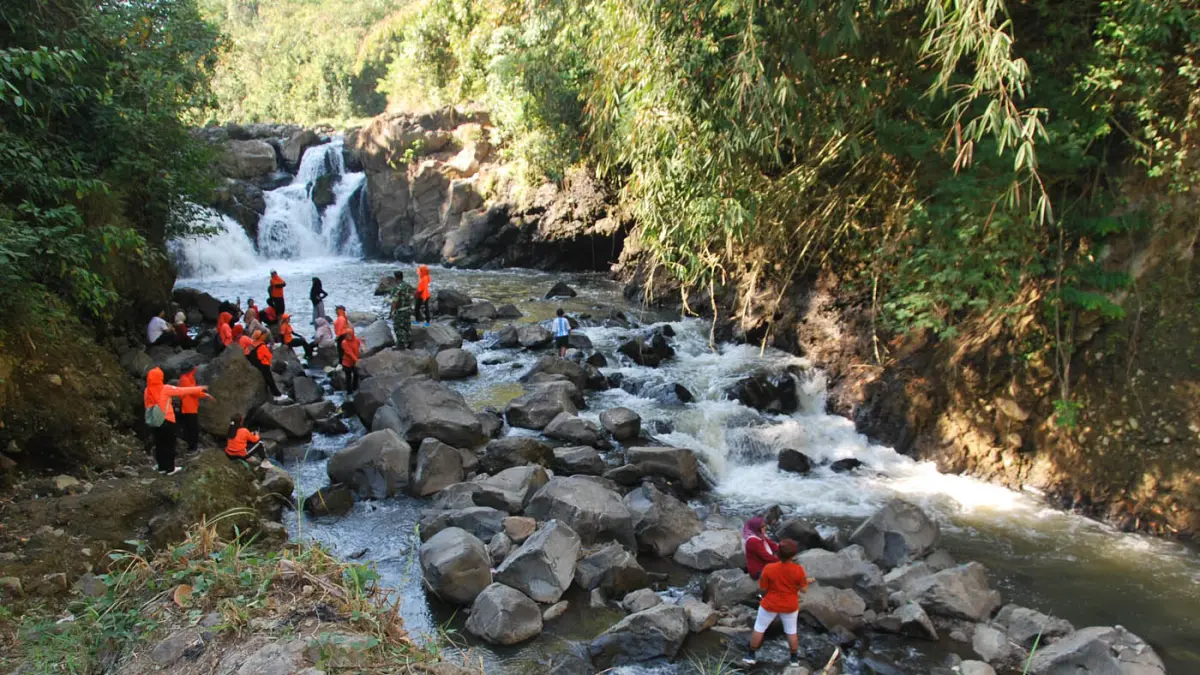 Pengunjung menikmati panorama air terjun Kedung Boto yang dikelilingi bebatuan alami dan rumpun bambu di Kelurahan Pudakpayung, Kota Semarang, Minggu (26/7/2026). (Nur Chamim/Jawa Pos Radar Semarang)