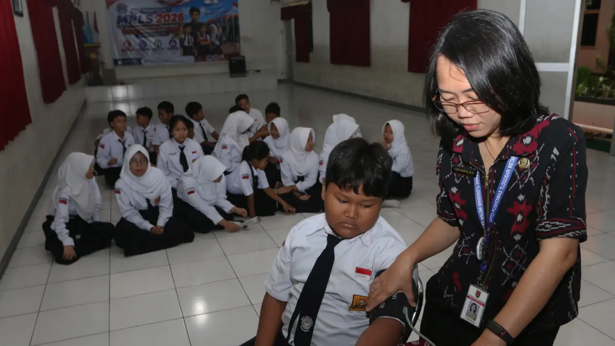 Petugas kesehatan dari UPTD Puskesmas Tlogosari Wetan memeriksa kesehatan siswa SMP Kesatrian 1,Saat pelaksanaan Cek Kesehatan Gratis (CKG),Kota Semarang,Selasa (28/7/2026). (Nur Chamim/Jawa Pos Radar Semarang)