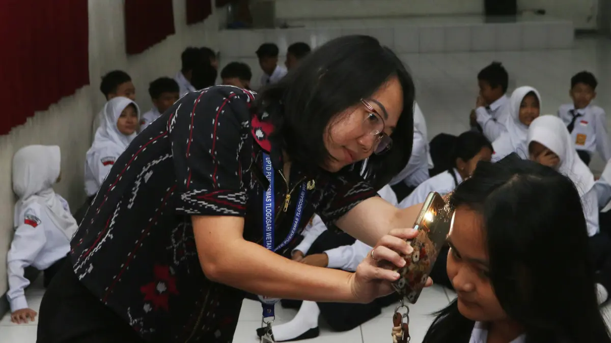 Petugas kesehatan dari UPTD Puskesmas Tlogosari Wetan memeriksa kesehatan siswa SMP Kesatrian 1,Saat pelaksanaan Cek Kesehatan Gratis (CKG),Kota Semarang,Selasa (28/7/2026). (Nur Chamim/Jawa Pos Radar Semarang)