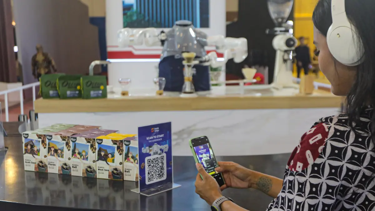 Pengunjung memindai kode batang Bank Saqu di Gaikindo Indonesia International Auto Show (GIIAS) 2026 di Indonesia Convention Exhibition (ICE) BSD, Serpong, Kabupaten Tangerang, Banten, Kamis (30/7/2026). (Salman Toyibi/Jawa Pos)