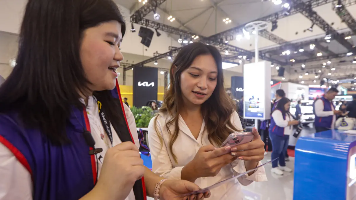 Petugas memberi informasi Bank Saqu kepada pengunjung Gaikindo Indonesia International Auto Show (GIIAS) 2026 di Indonesia Convention Exhibition (ICE) BSD, Serpong, Kabupaten Tangerang, Banten, Kamis (30/7/2026). (Salman Toyibi/Jawa Pos)