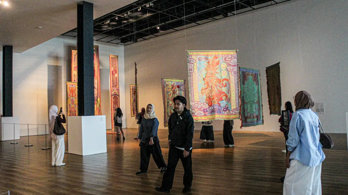 Pengunjung melihat karya Marcos Kueh di pameran Marcos Kueh: Kenyalang Circus di Museum Macan, Sabtu (01/08/2026). (Hanung Hambara/Jawa Pos)
