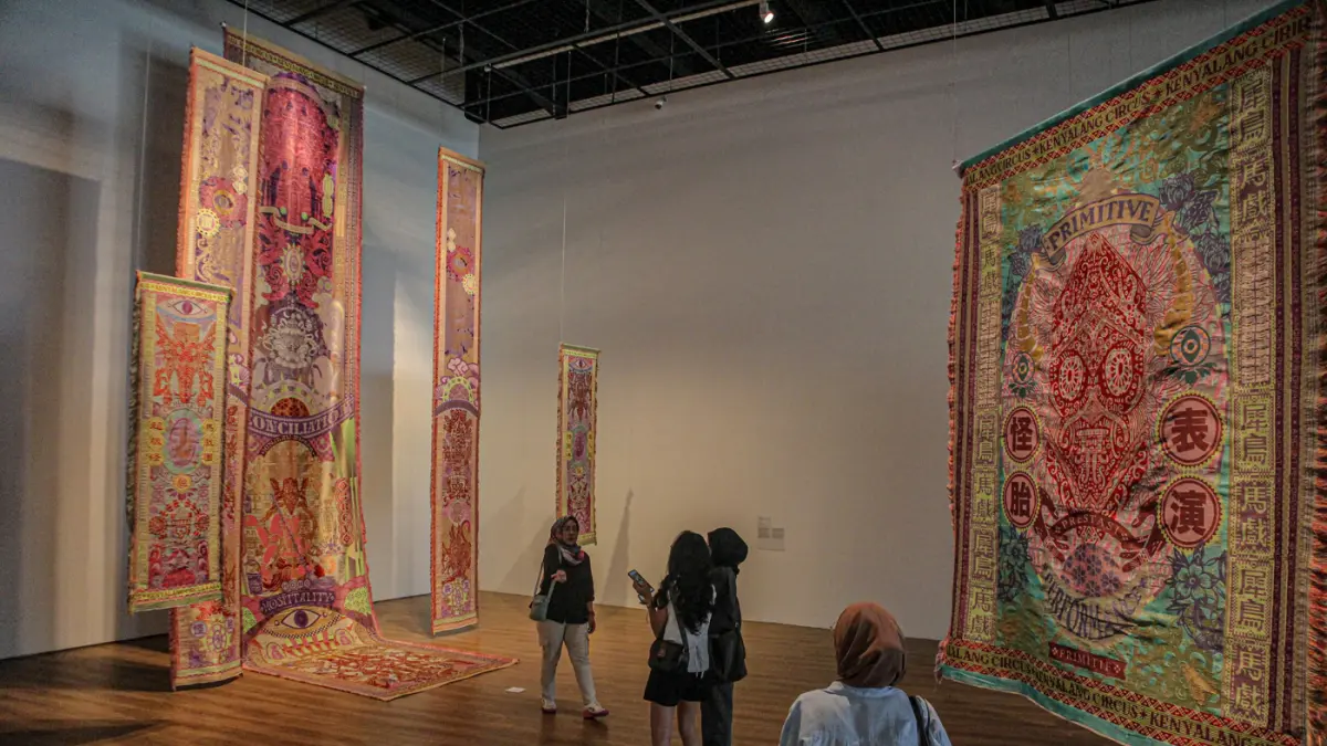 Pengunjung melihat karya Marcos Kueh di pameran Marcos Kueh: Kenyalang Circus di Museum Macan, Sabtu (01/08/2026). (Hanung Hambara/Jawa Pos)