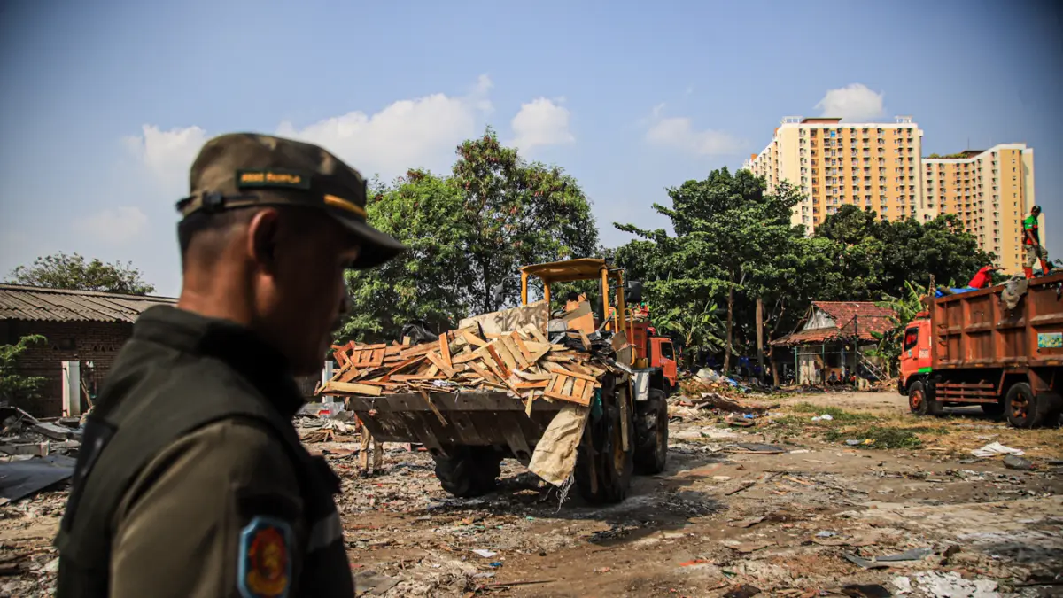 Sejumlah petugas gabungan membersihkan puing bangunan liar yang telah dirobohkan di Jalan Rasamala Hijau, Jakarta Barat, Kamis (30/07/2026). (Hanung Hambara/Jawa Pos)
