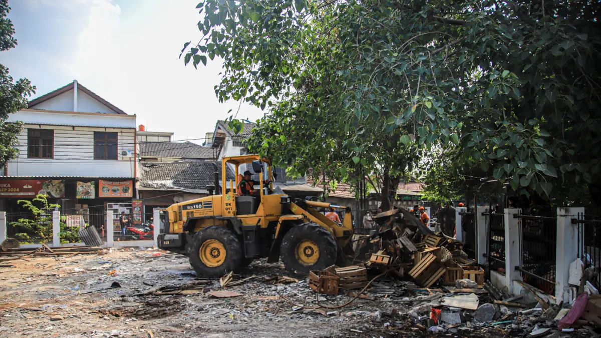 Sejumlah petugas gabungan membersihkan puing bangunan liar yang telah dirobohkan di Jalan Rasamala Hijau, Jakarta Barat, Kamis (30/07/2026). (Hanung Hambara/Jawa Pos)