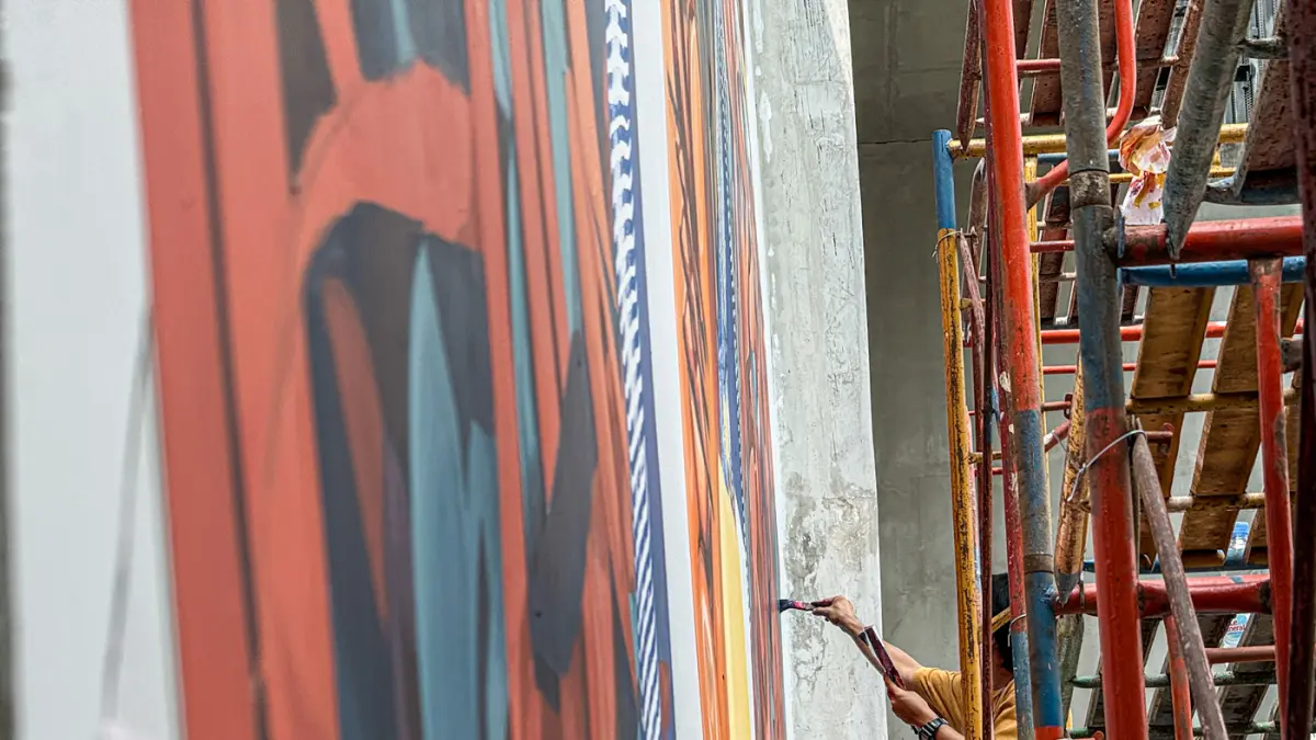 Seniman melukis mural karya kolaborasi tiga seniman, yakni Vitalii Dilkone (Ukraina), Muna Diannur (Indonesia) dan Manuel Skirl (Austria) di salah satu dinding Taman Ismail Marzuki (TIM), Menteng, Jakarta Pusat, Kamis (30/07/2026). (Hanung Hambara/Jawa Po