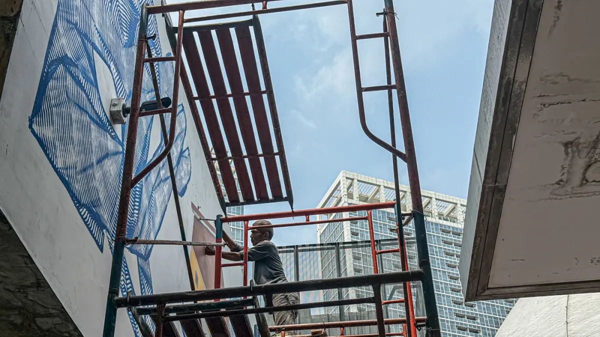 Seniman melukis mural karya kolaborasi tiga seniman, yakni Vitalii Dilkone (Ukraina), Muna Diannur (Indonesia) dan Manuel Skirl (Austria) di salah satu dinding Taman Ismail Marzuki (TIM), Menteng, Jakarta Pusat, Kamis (30/07/2026). (Hanung Hambara/Jawa Po
