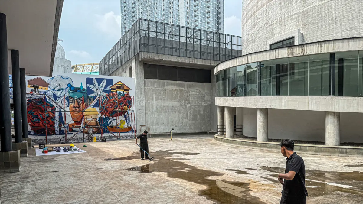 Seniman melukis mural karya kolaborasi tiga seniman, yakni Vitalii Dilkone (Ukraina), Muna Diannur (Indonesia) dan Manuel Skirl (Austria) di salah satu dinding Taman Ismail Marzuki (TIM), Menteng, Jakarta Pusat, Kamis (30/07/2026). (Hanung Hambara/Jawa Po