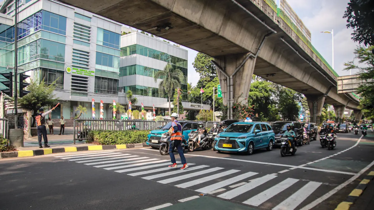 Sejumlah pejalan kaki melintas menggunakan fasilitas Pelican Crossing di Jalan Kapten Tendean, Jakarta, Selasa (04/08/2026). (Hanung Hambara/Jawa Pos)