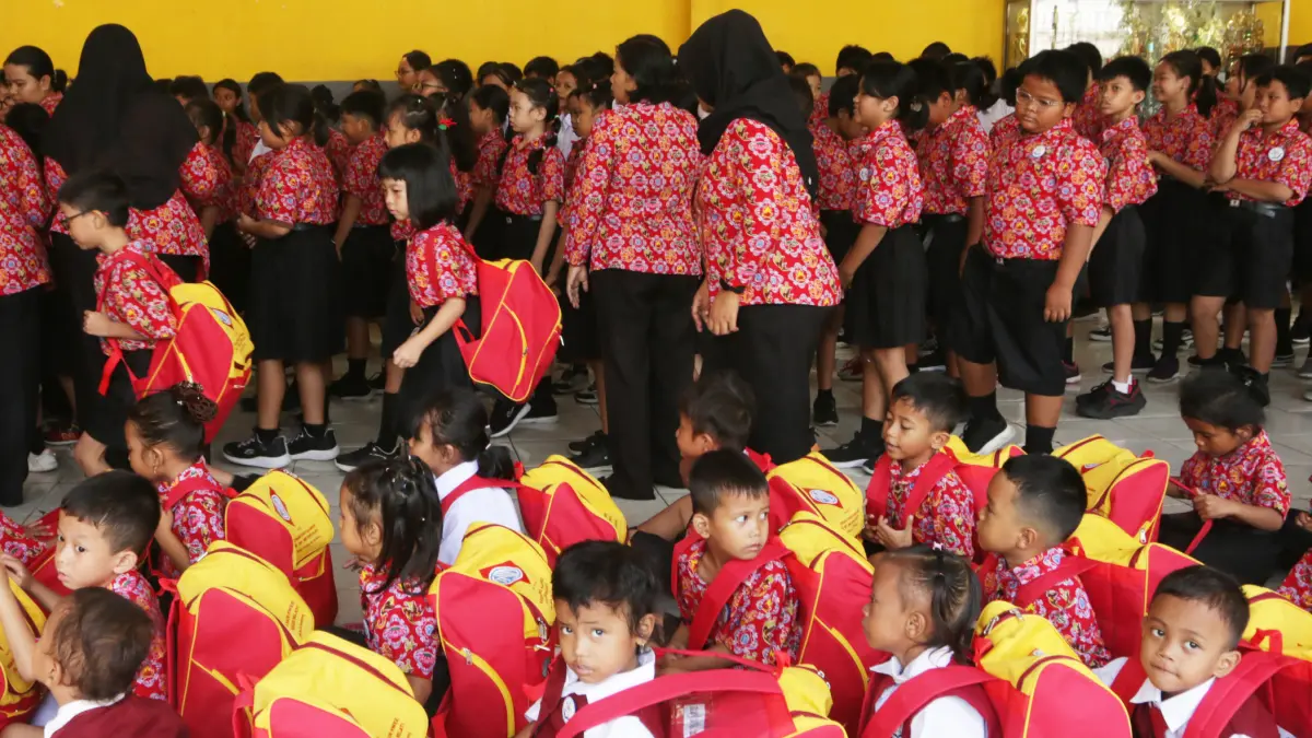 Seorang siswa melihat isi tas perlengkapan sekolah yang diterimanya di Sekolah Gratis Kuncup Melati,Kota Semarang, Jawa Tengah, Selasa (4/8/2026)