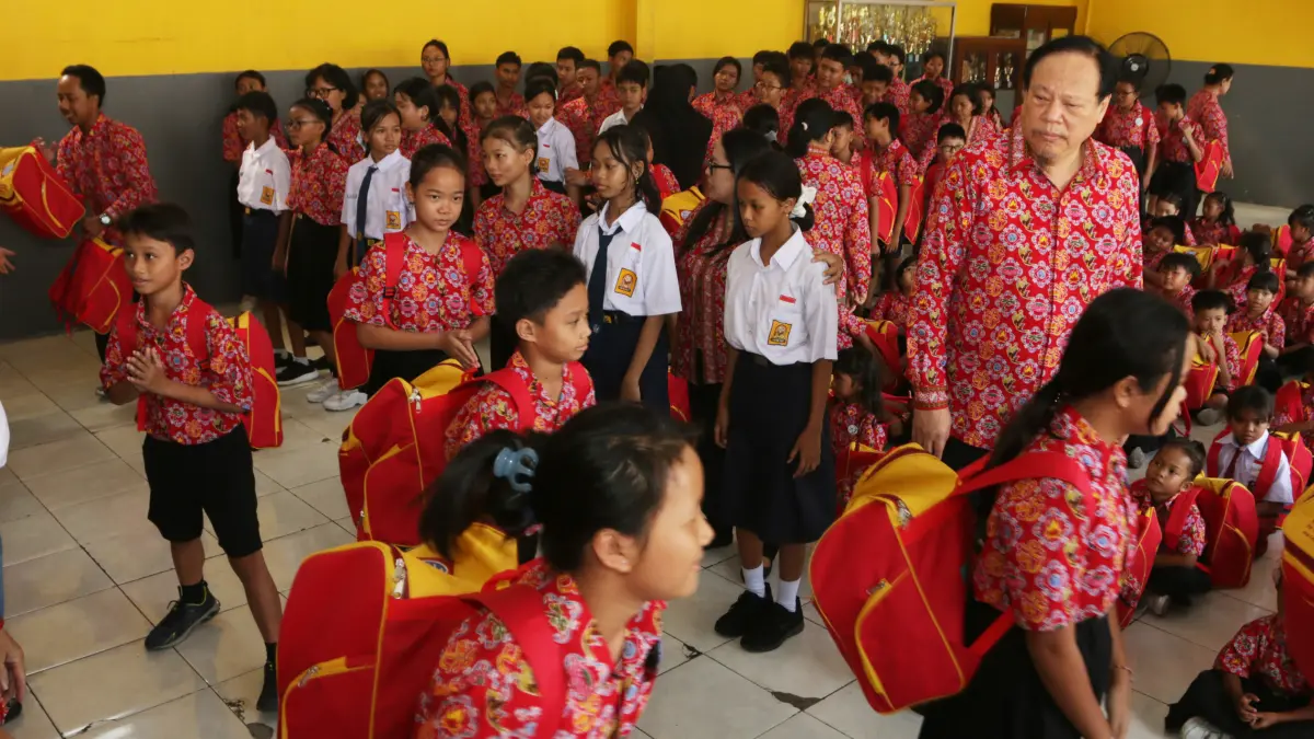 Siswa menerima tas berisi paket perlengkapan sekolah di Sekolah Gratis Kuncup Melati,Kota Semarang, Jawa Tengah, Selasa (4/8/2026).
