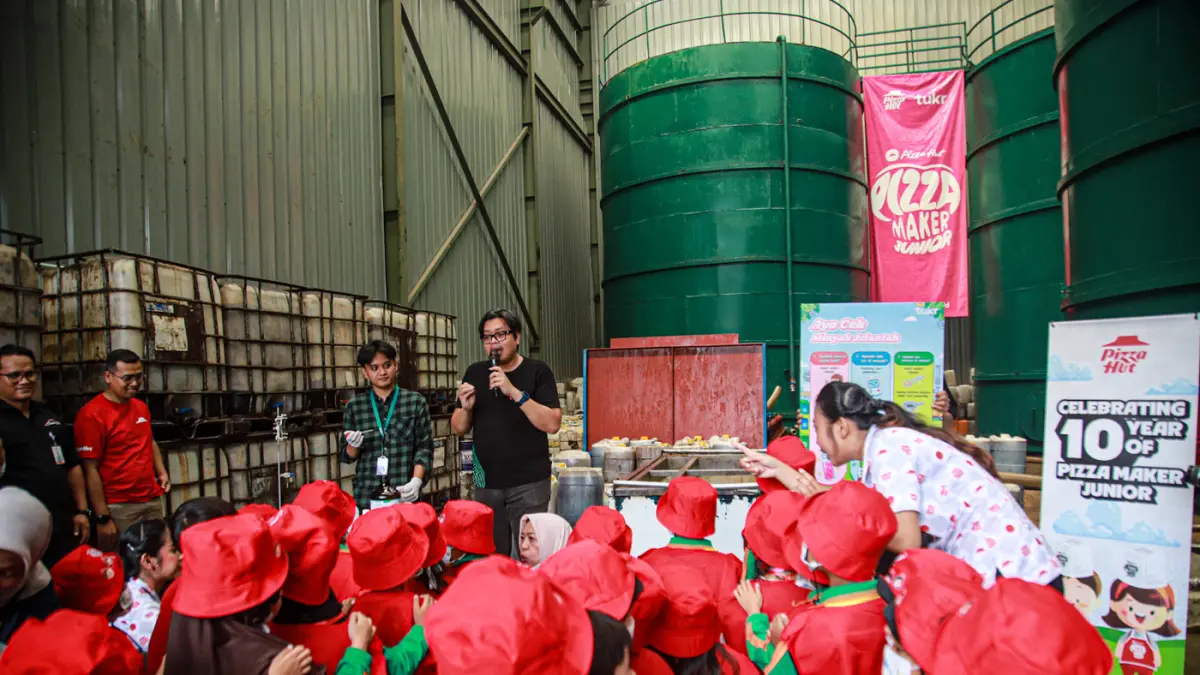 Peserta Pizza Maker Junior mempraktikkan langsung cara mengumpulkan minyak jelantah dengan benar melalui pendampingan tim Pizza Hut Indonesia dan TUKR di TUKR Harapan Indah, Bekasi, Selasa (04/08/2026). (Hanung Hambara/Jawa Pos)