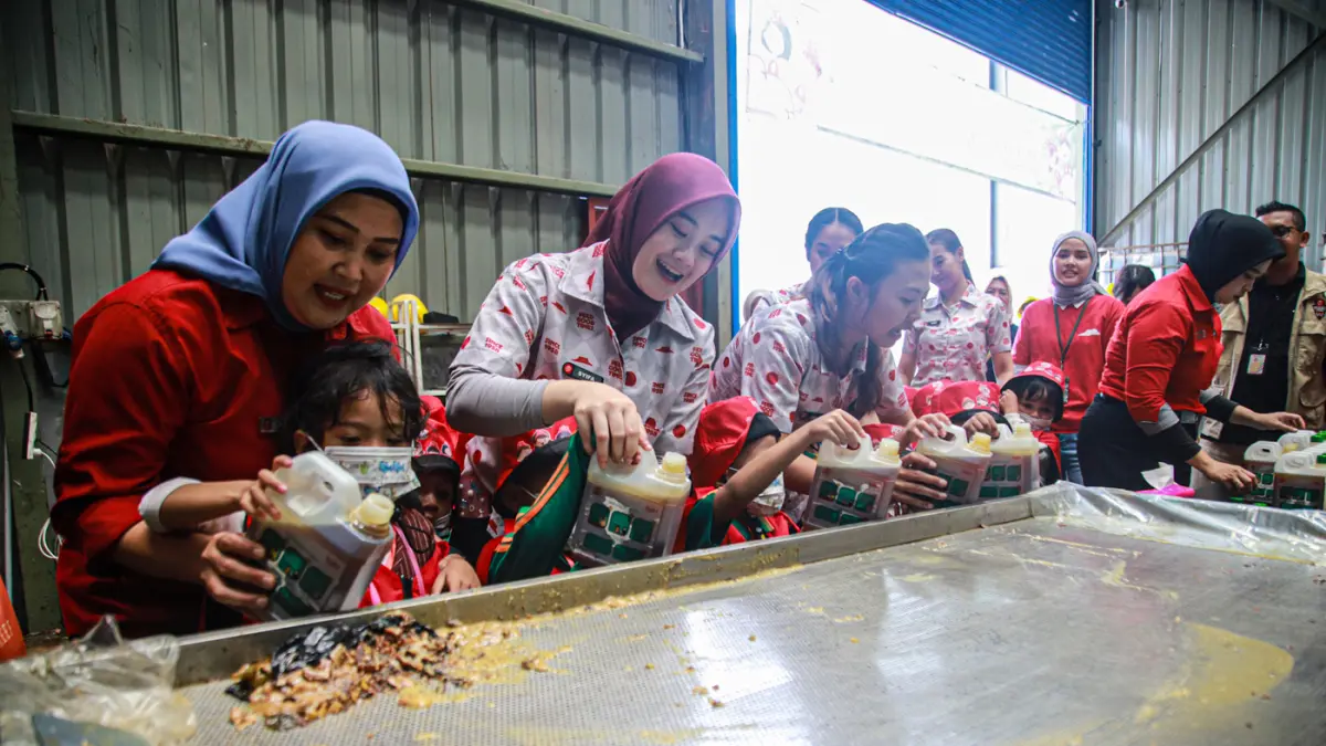 Peserta Pizza Maker Junior mempraktikkan langsung cara mengumpulkan minyak jelantah dengan benar melalui pendampingan tim Pizza Hut Indonesia dan TUKR di TUKR Harapan Indah, Bekasi, Selasa (04/08/2026). (Hanung Hambara/Jawa Pos)