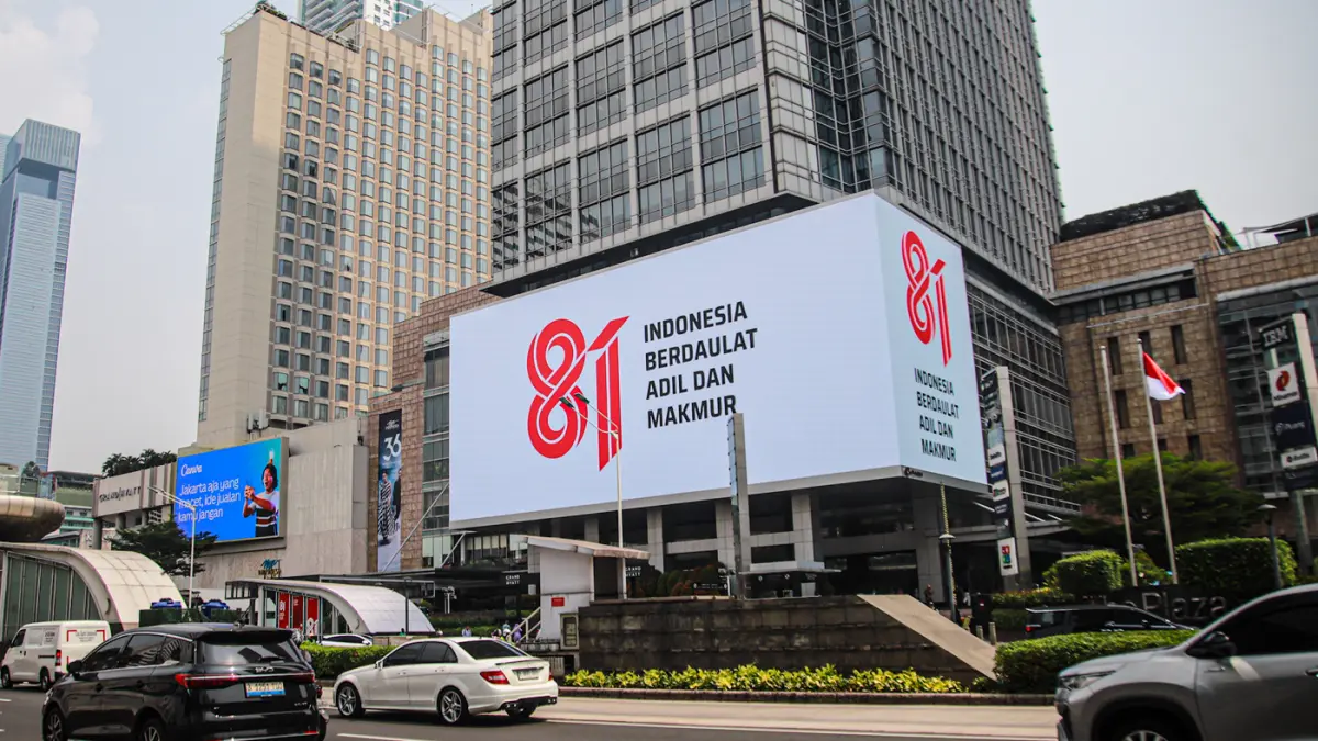 Sejumlah pengendara melintas di samping logo HUT RI ke-81 di Jalan M.H. Thamrin, Jakarta, Kamis (06/08/2026). (Hanung Hambara/Jawa Pos)