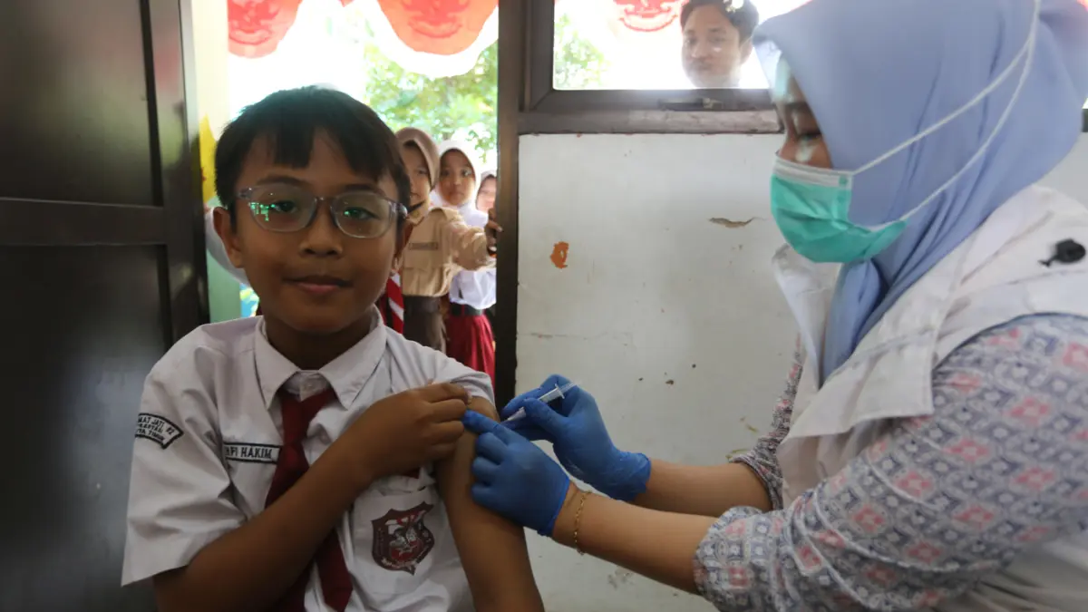 Tenaga Kesehatan membimbing siswi untuk mengikuti pemeriksaan kesehatan gratis melalui Program Cek Kesehatan Gratis (CKG) dan Bulan Imunisasi Anak Sekolah (BIAS) di SDN Kramat Jati 02 Pagi, Jakarta Timur, Kamis (6/8/2026). (Dery Ridwansah/ JawaPos.com)