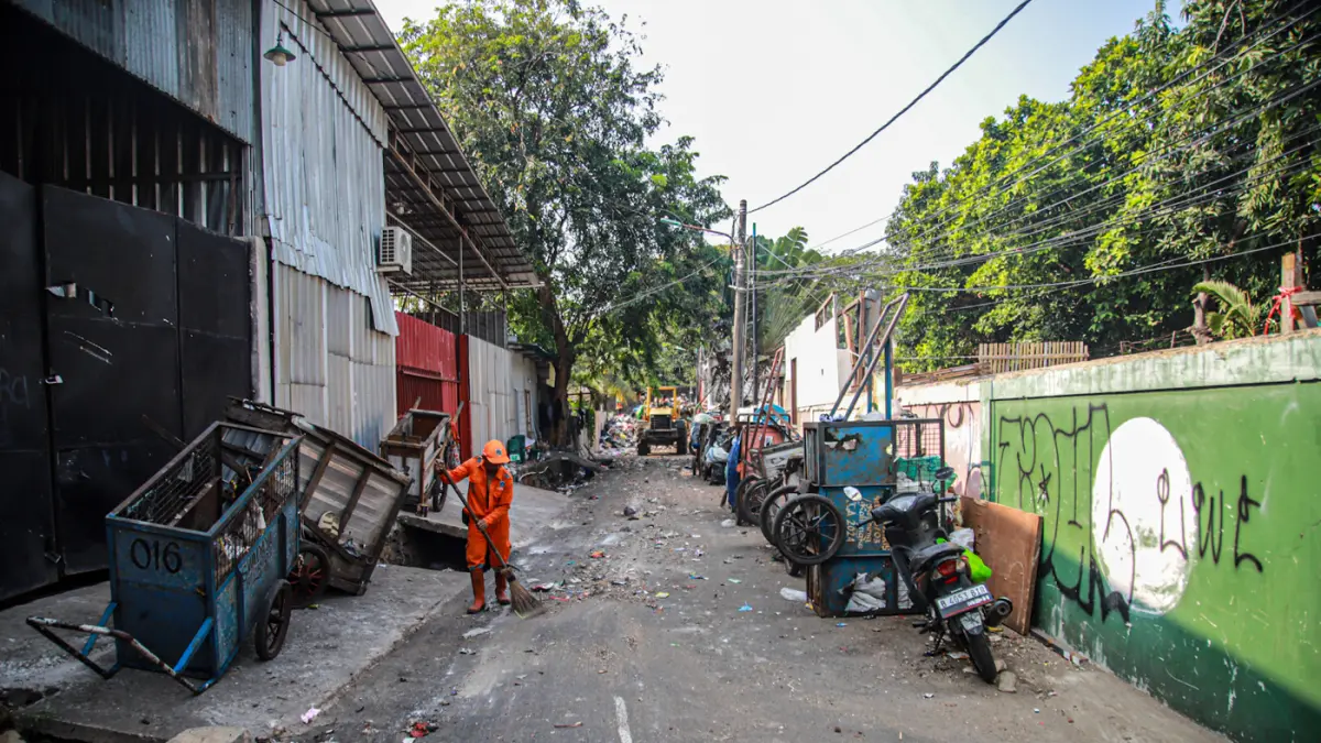 Sejumlah petugas dari PPSU dan Dinas LH Provinsi DKI Jakarta membersihkan tumpukan sampah yang menutup akses jalan di Kedaung Kali Angke, Cengkareng, Jakarta, Jumat (07/08/2026). (Hanung Hambara/Jawa Pos)