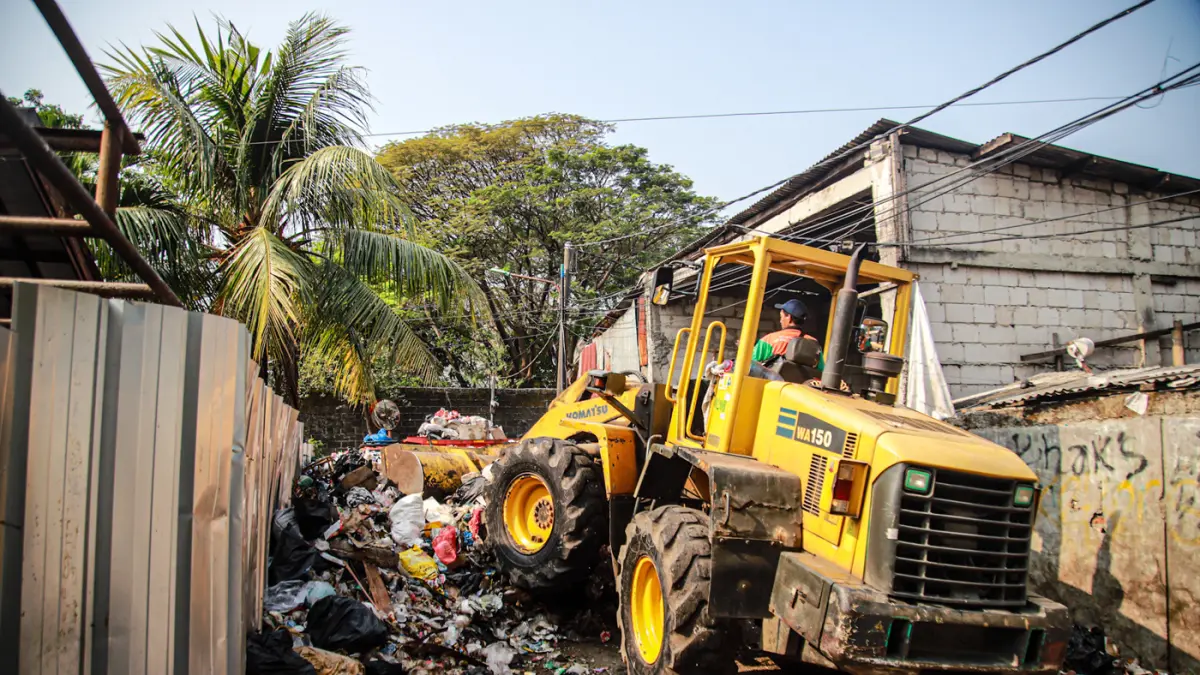 Sejumlah petugas dari PPSU dan Dinas LH Provinsi DKI Jakarta membersihkan tumpukan sampah yang menutup akses jalan di Kedaung Kali Angke, Cengkareng, Jakarta, Jumat (07/08/2026). (Hanung Hambara/Jawa Pos)