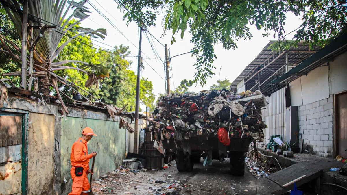 Sejumlah petugas dari PPSU dan Dinas LH Provinsi DKI Jakarta membersihkan tumpukan sampah yang menutup akses jalan di Kedaung Kali Angke, Cengkareng, Jakarta, Jumat (07/08/2026). (Hanung Hambara/Jawa Pos)