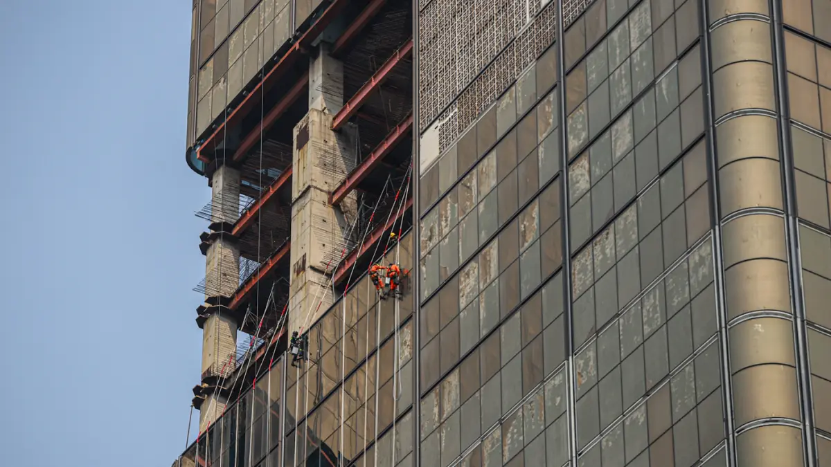 Pekerja memasang kaca gedung di kawasan Jalan M.H. Thamrin, Jakarta, Jumat (07/08/2026). (Hanung Hambara/Jawa Pos)