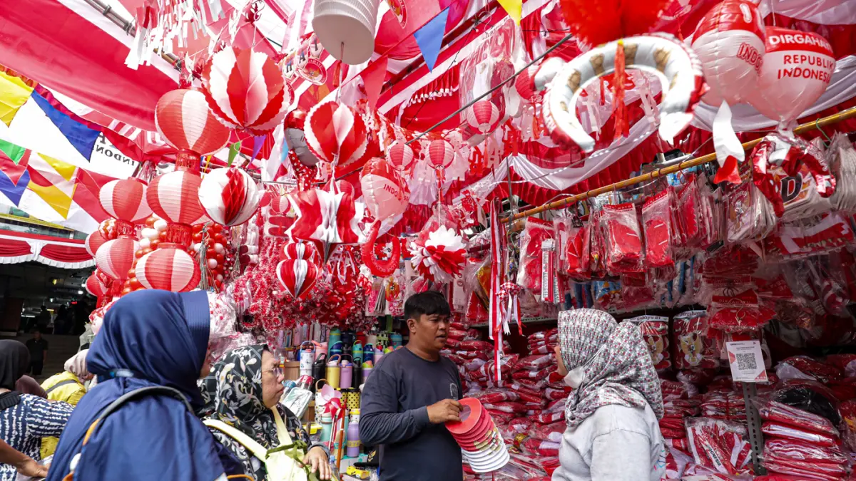 Pembeli yang memilih atribut dan pernak-pernik Hari Ulang Tahun (HUT) ke-81 Republik Indonesia di Pasar Jatinegara, Jakarta, Jumat (7/8/2026). (Salman Toyibi/Jawa Pos)