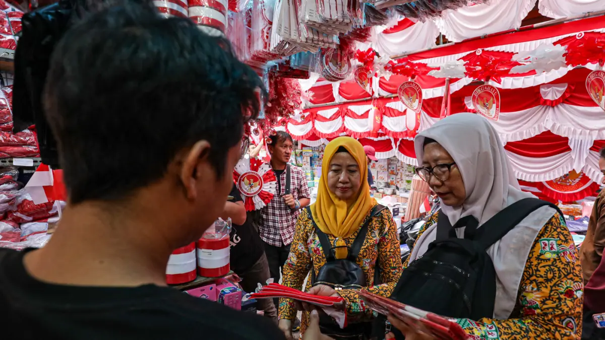 Pembeli yang memilih atribut dan pernak-pernik Hari Ulang Tahun (HUT) ke-81 Republik Indonesia di Pasar Jatinegara, Jakarta, Jumat (7/8/2026). (Salman Toyibi/Jawa Pos)