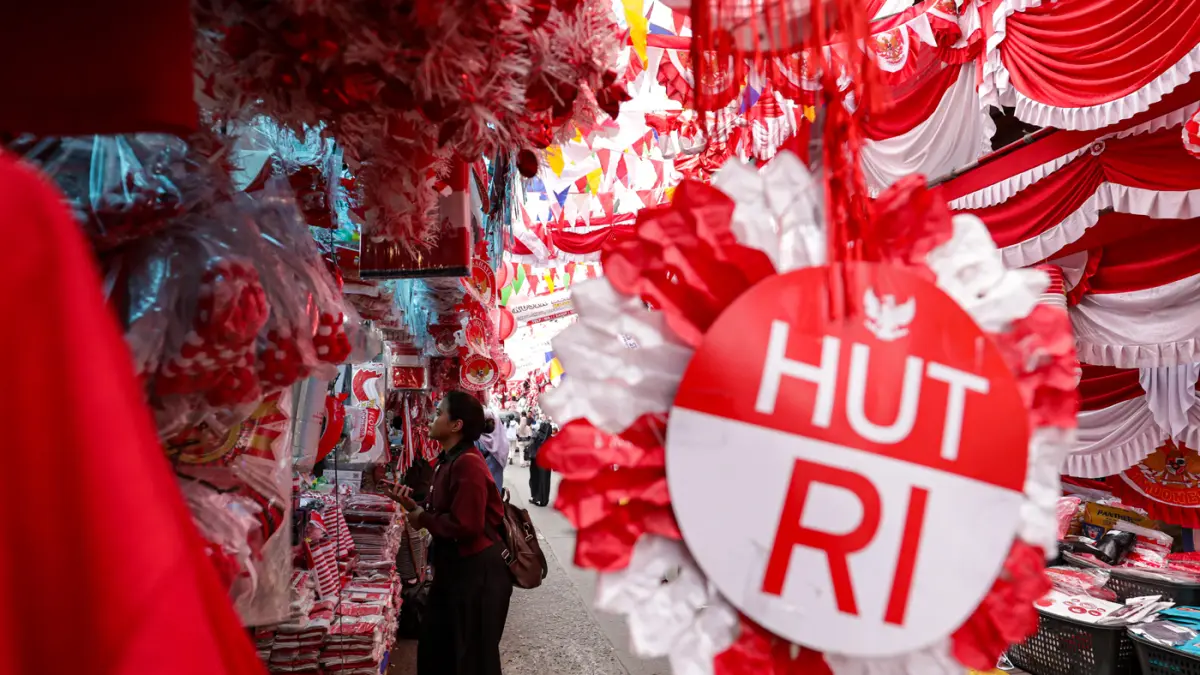 Pembeli yang memilih atribut dan pernak-pernik Hari Ulang Tahun (HUT) ke-81 Republik Indonesia di Pasar Jatinegara, Jakarta, Jumat (7/8/2026). (Salman Toyibi/Jawa Pos)