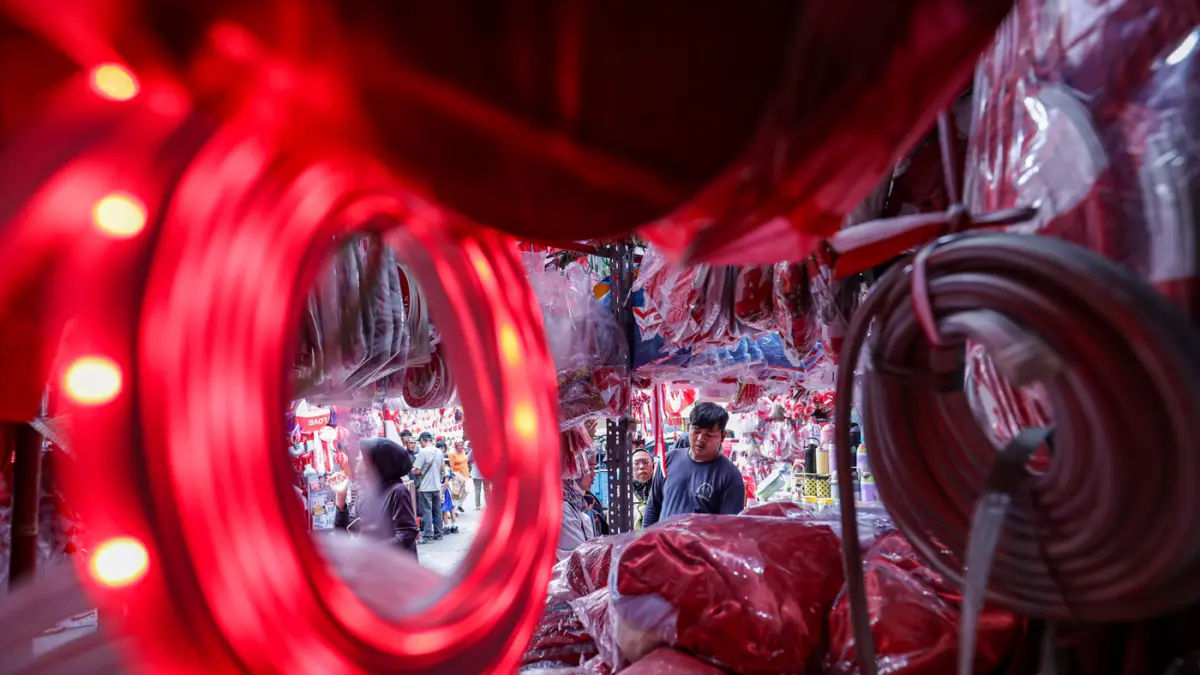 Pembeli yang memilih atribut dan pernak-pernik Hari Ulang Tahun (HUT) ke-81 Republik Indonesia di Pasar Jatinegara, Jakarta, Jumat (7/8/2026). (Salman Toyibi/Jawa Pos)