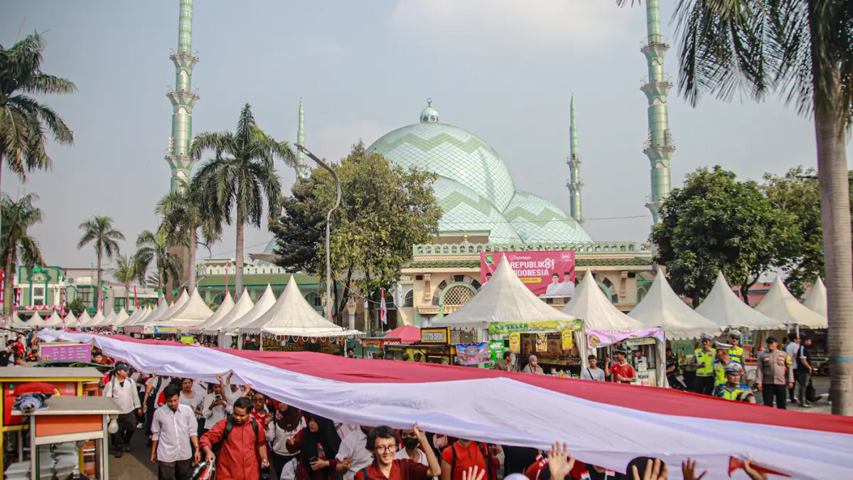 Peserta mengikuti kirab bendera merah putih di Kota Tangerang, Minggu (16/08/2026). (Hanung Hambara/Jawa Pos)