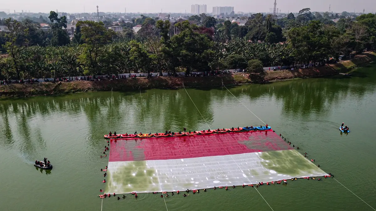 Foto udara relawan membentangkan bendera Merah Putih di Situ Gintung, Tangerang Selatan, Banten, Senin (17/8/2026). (Hanung Hambara/Jawa Pos)